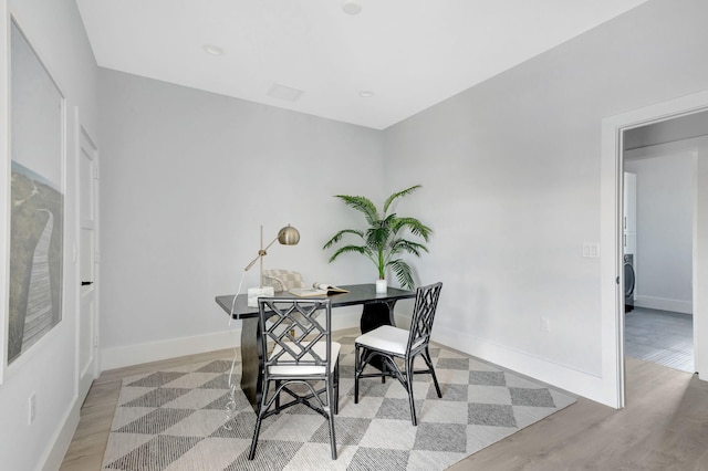 home office with light wood-style floors, baseboards, and washer / dryer