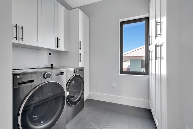 washroom featuring separate washer and dryer, cabinet space, baseboards, and dark tile patterned flooring