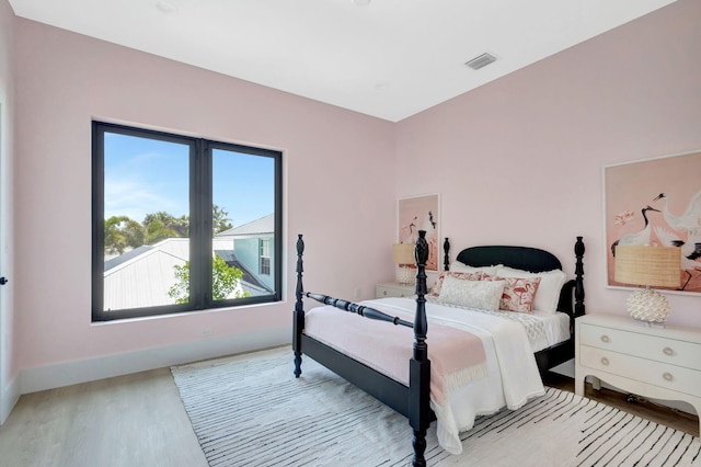 bedroom with wood finished floors and baseboards