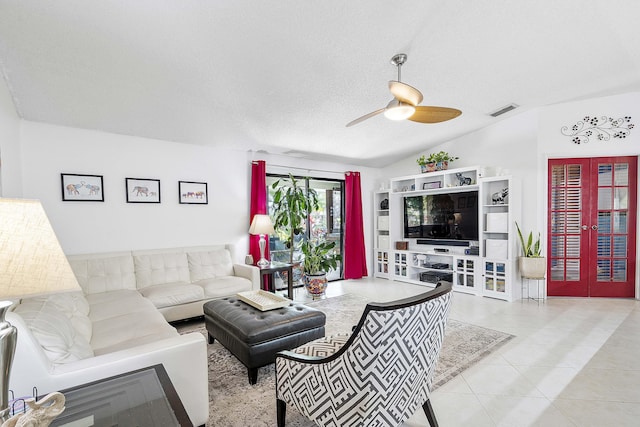 tiled living area featuring a ceiling fan, vaulted ceiling, and a textured ceiling