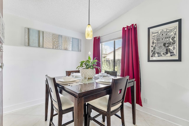 dining area featuring a textured ceiling, baseboards, and light tile patterned floors