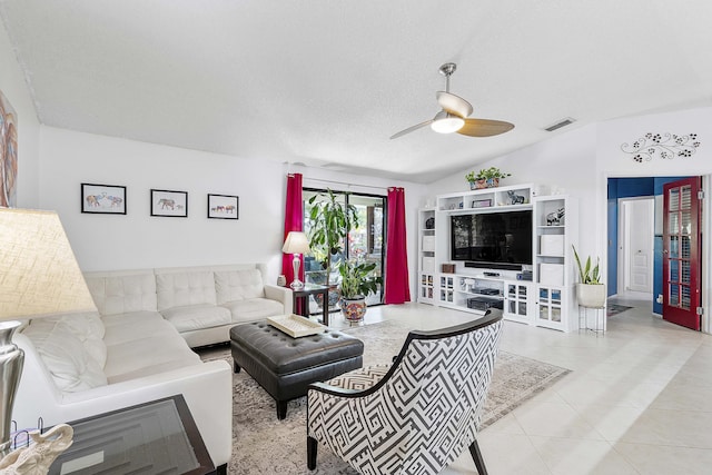 living room with ceiling fan, tile patterned flooring, and a textured ceiling