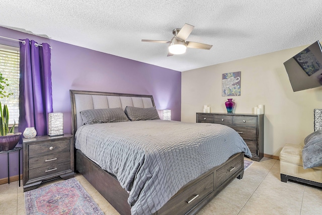 bedroom with light tile patterned flooring, a textured ceiling, ceiling fan, and baseboards