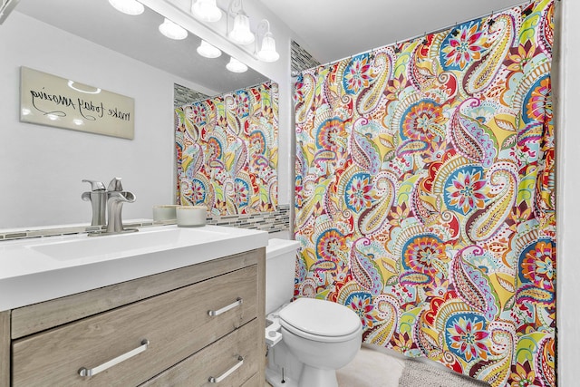 bathroom with toilet, vanity, and a shower with shower curtain