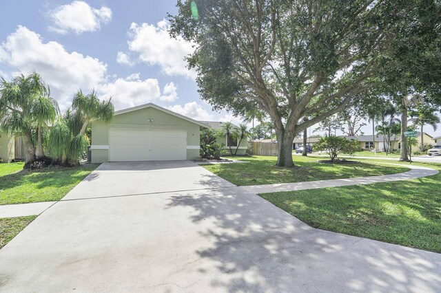 ranch-style house with a front lawn, driveway, an attached garage, and stucco siding