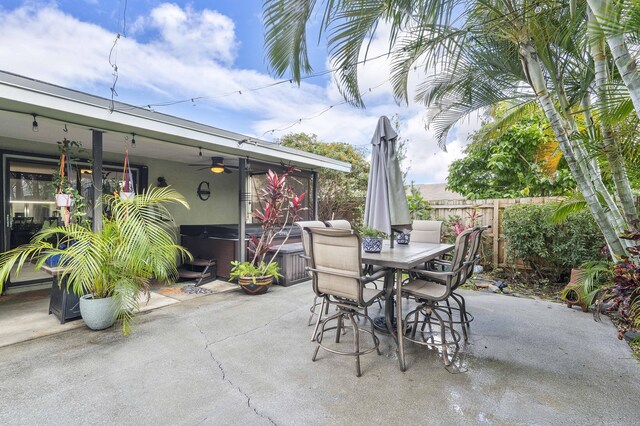 view of patio featuring a hot tub, fence, ceiling fan, and outdoor dining space