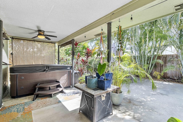 view of patio / terrace featuring a hot tub, ceiling fan, and fence