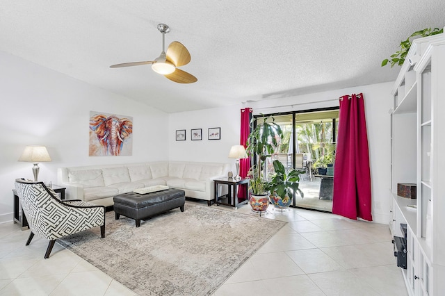 living area featuring a ceiling fan, light tile patterned floors, a textured ceiling, and vaulted ceiling