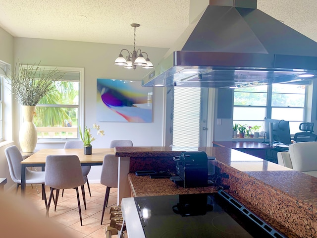 dining room with healthy amount of natural light, a textured ceiling, a chandelier, and light tile patterned floors
