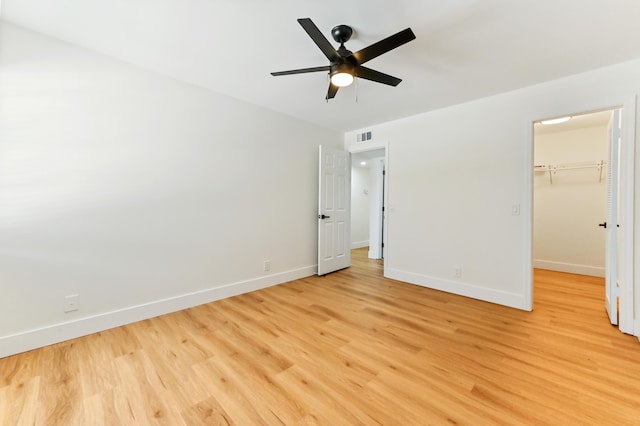 278 Normandy F, Delray Beach, FL 33484 - unfurnished bedroom with light wood finished floors, baseboards, a spacious closet, a closet, and a ceiling fan