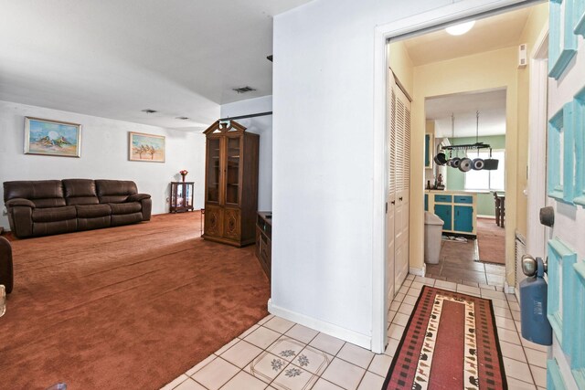 1402 SE Buckingham Ter, Port Saint Lucie, FL 34952 - hallway with light tile patterned floors, light colored carpet, and baseboards