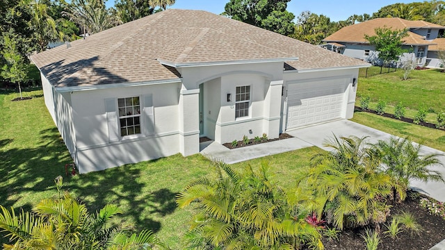 single story home with roof with shingles, a front yard, a garage, and concrete driveway