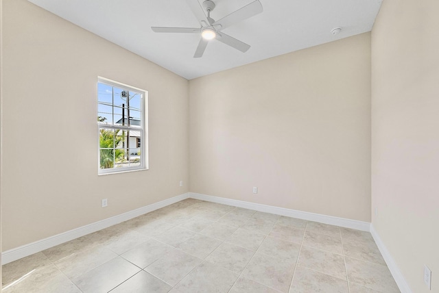 empty room featuring baseboards, ceiling fan, and light tile patterned floors