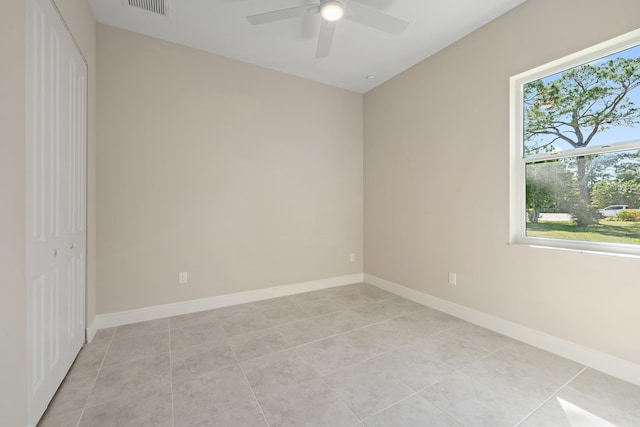 unfurnished room featuring a ceiling fan, light tile patterned floors, and baseboards