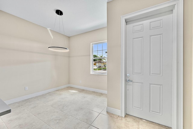 foyer featuring baseboards and light tile patterned floors