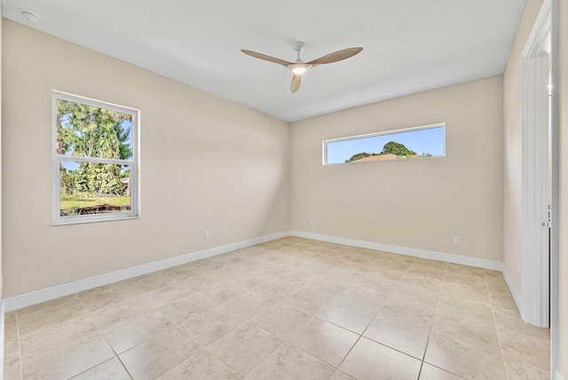 spare room featuring a ceiling fan, light tile patterned flooring, and baseboards