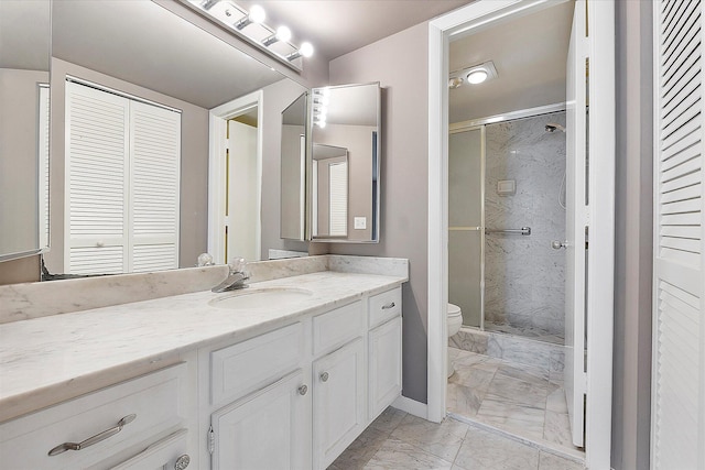 bathroom with marble finish flooring, a shower stall, toilet, and vanity