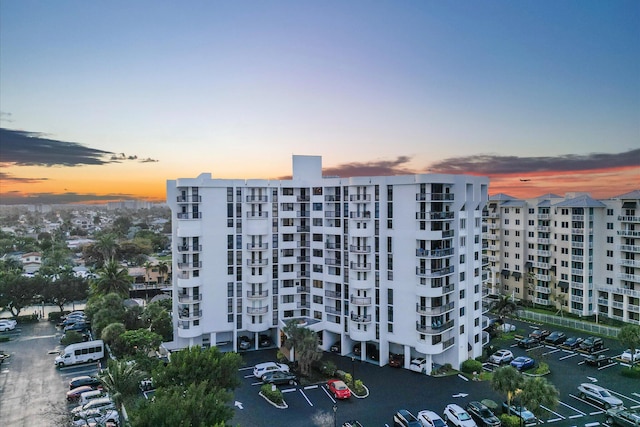 property at dusk featuring a view of apartment building / complex