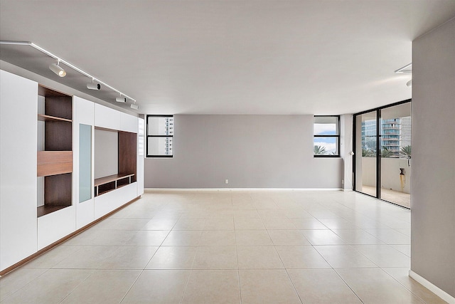 spare room with light tile patterned flooring and baseboards