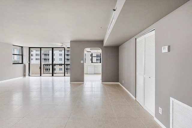 unfurnished living room featuring light tile patterned floors and baseboards