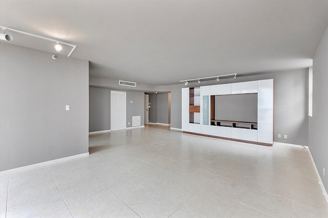 unfurnished living room with track lighting, light tile patterned flooring, and baseboards