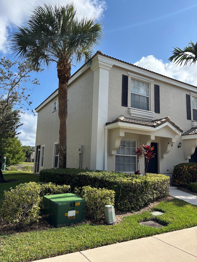 view of front facade featuring stucco siding and a tiled roof