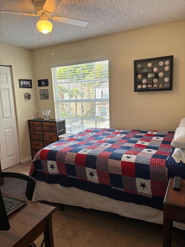 bedroom featuring carpet floors, a textured ceiling, and a ceiling fan