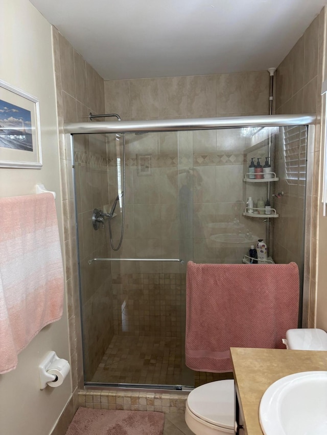 bathroom with a stall shower, vanity, and toilet