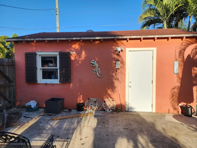 832 N D St, Lake Worth Beach, FL 33460 - rear view of property with stucco siding, fence, central AC unit, a patio area, and a shingled roof