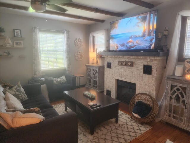 832 N D St, Lake Worth Beach, FL 33460 - living room with wood finished floors, a ceiling fan, a fireplace, and beamed ceiling