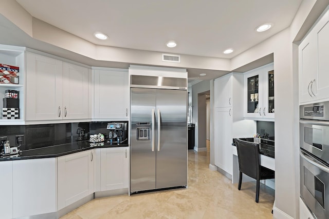 3610 Gardens Pkwy Unit 403A, Palm Beach Gardens, FL 33410 - kitchen featuring stainless steel appliances, white cabinets, dark countertops, glass insert cabinets, and recessed lighting