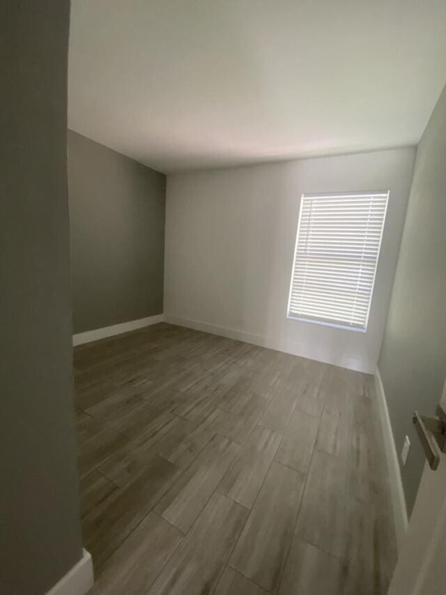 spare room with wood finished floors and baseboards