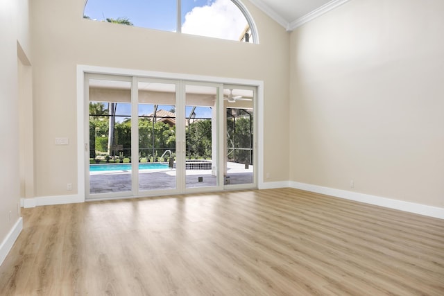 3333 Southern Cay Dr, Jupiter, FL 33477 - unfurnished room featuring ornamental molding, healthy amount of natural light, wood finished floors, baseboards, and a high ceiling