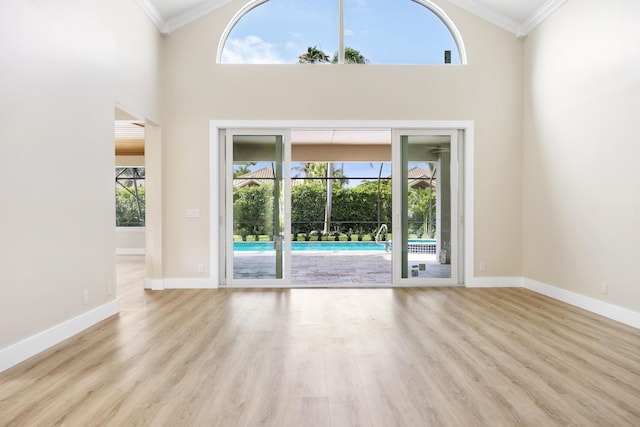 3333 Southern Cay Dr, Jupiter, FL 33477 - unfurnished living room with ornamental molding, wood finished floors, baseboards, and a high ceiling