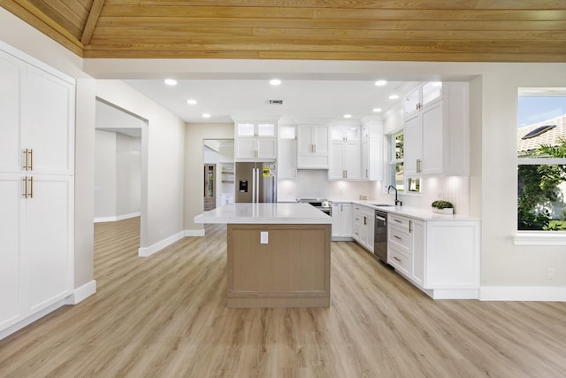 3333 Southern Cay Dr, Jupiter, FL 33477 - kitchen with appliances with stainless steel finishes, a sink, light wood finished floors, baseboards, and a center island