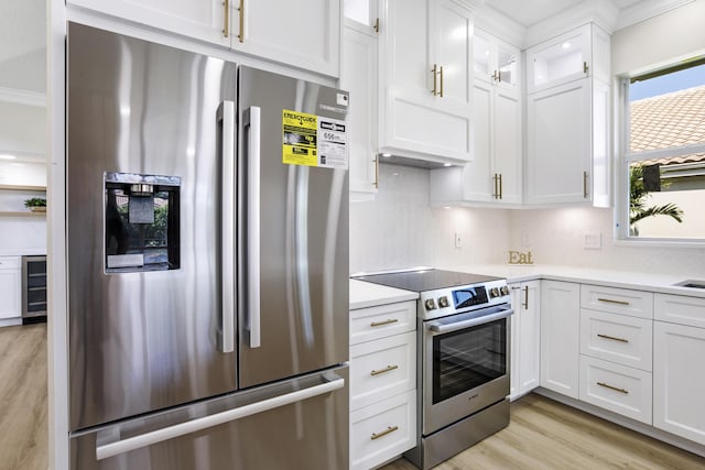 3333 Southern Cay Dr, Jupiter, FL 33477 - kitchen with appliances with stainless steel finishes, wine cooler, light wood finished floors, white cabinets, and light countertops
