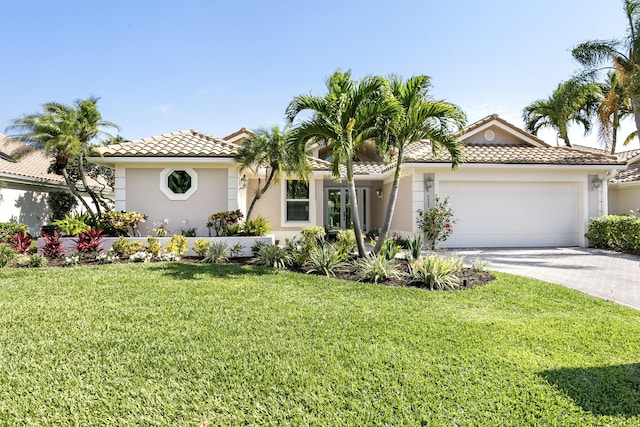3333 Southern Cay Dr, Jupiter, FL 33477 - mediterranean / spanish house with stucco siding, an attached garage, a tiled roof, a front yard, and driveway