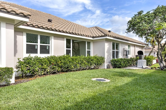 3333 Southern Cay Dr, Jupiter, FL 33477 - back of property with a tiled roof, stucco siding, and a lawn