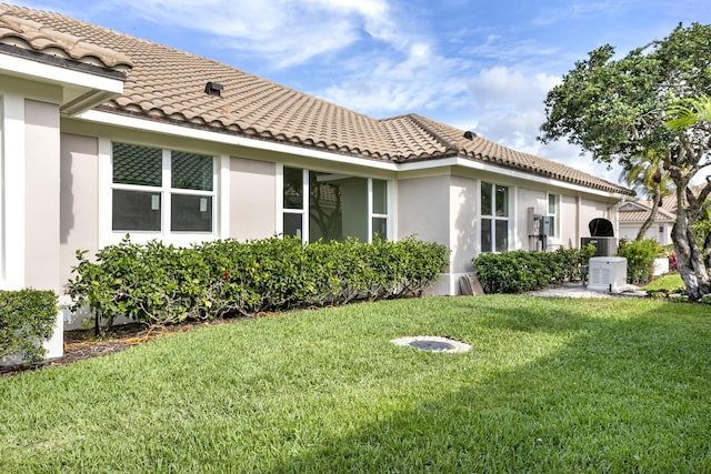 3333 Southern Cay Dr, Jupiter, FL 33477 - back of house with a tiled roof, stucco siding, and a lawn
