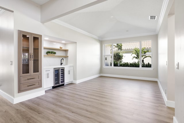 3333 Southern Cay Dr, Jupiter, FL 33477 - indoor wet bar with wine cooler, ornamental molding, light wood finished floors, lofted ceiling, and baseboards