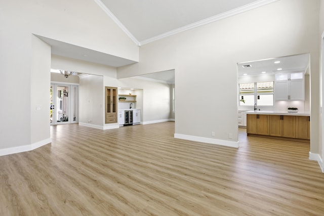3333 Southern Cay Dr, Jupiter, FL 33477 - unfurnished living room with ornamental molding, high vaulted ceiling, light wood-style flooring, baseboards, and a chandelier