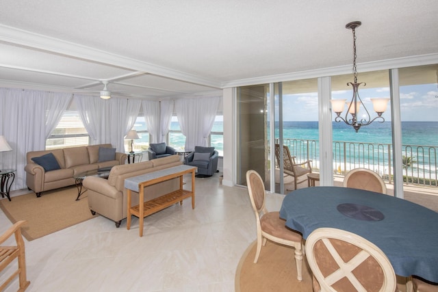 3230 S Ocean Blvd Unit D511, Palm Beach, FL 33480 - living room featuring a chandelier, a water view, ornamental molding, light tile patterned floors, and ceiling fan