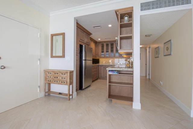 3230 S Ocean Blvd Unit D511, Palm Beach, FL 33480 - kitchen featuring open shelves, freestanding refrigerator, backsplash, glass insert cabinets, and ornamental molding