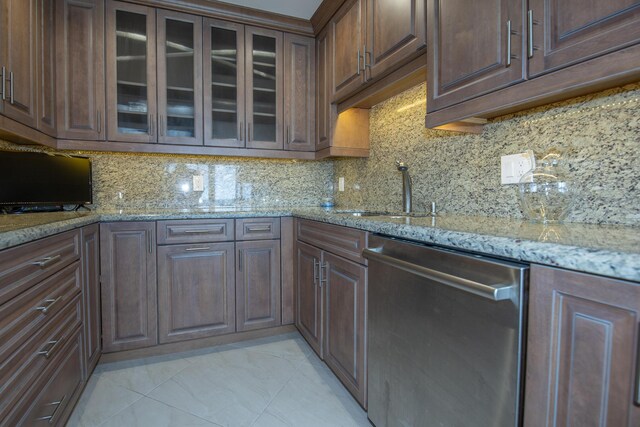 3230 S Ocean Blvd Unit D511, Palm Beach, FL 33480 - kitchen featuring dishwasher, a sink, glass insert cabinets, light stone counters, and backsplash
