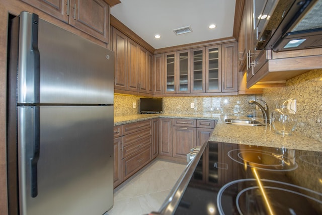 3230 S Ocean Blvd Unit D511, Palm Beach, FL 33480 - kitchen featuring freestanding refrigerator, a sink, glass insert cabinets, tasteful backsplash, and light tile patterned flooring