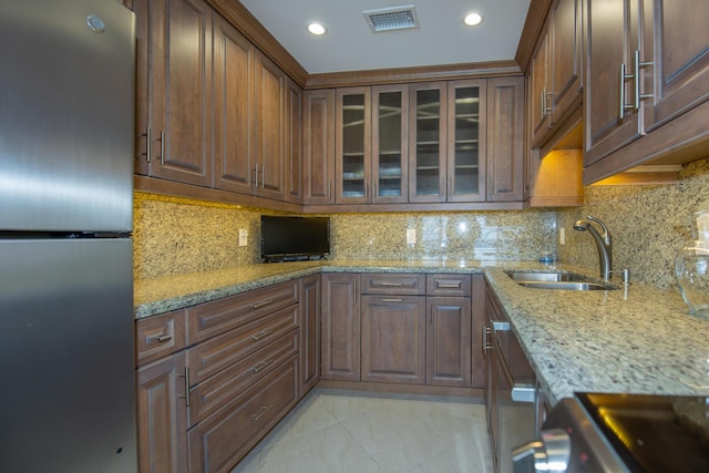 3230 S Ocean Blvd Unit D511, Palm Beach, FL 33480 - kitchen featuring stainless steel refrigerator, a sink, glass insert cabinets, light stone counters, and tasteful backsplash