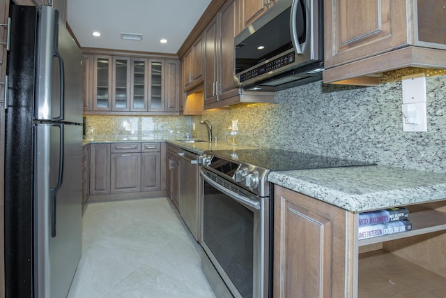 3230 S Ocean Blvd Unit D511, Palm Beach, FL 33480 - kitchen with appliances with stainless steel finishes, a sink, light stone countertops, decorative backsplash, and recessed lighting