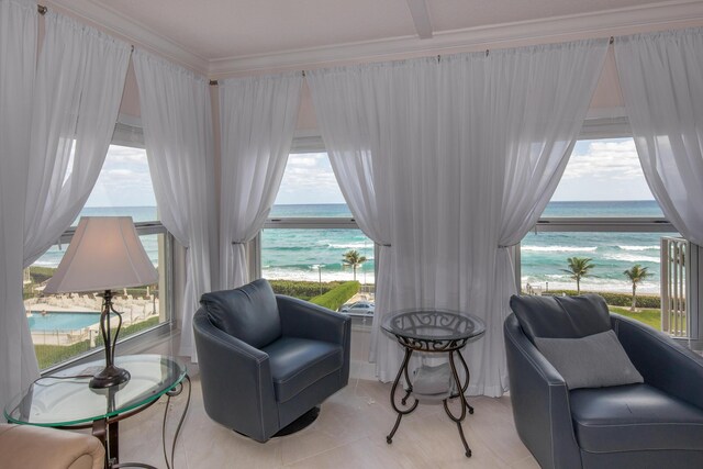 3230 S Ocean Blvd Unit D511, Palm Beach, FL 33480 - living area featuring view of water and beach, crown molding, and light tile patterned flooring