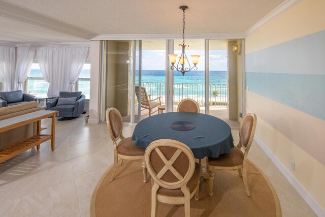 3230 S Ocean Blvd Unit D511, Palm Beach, FL 33480 - dining space featuring a chandelier, ornamental molding, baseboards, expansive windows, and a textured ceiling