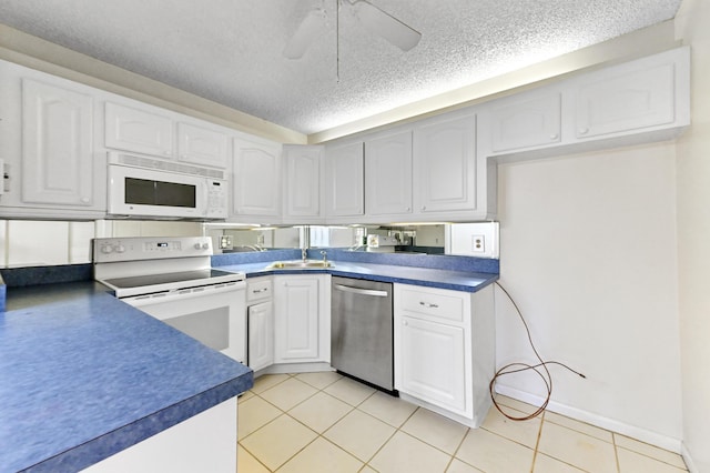 302 Knotty Pine Cir Unit D-1, Greenacres, FL 33463 - kitchen featuring white appliances, dark countertops, white cabinetry, a textured ceiling, and a sink